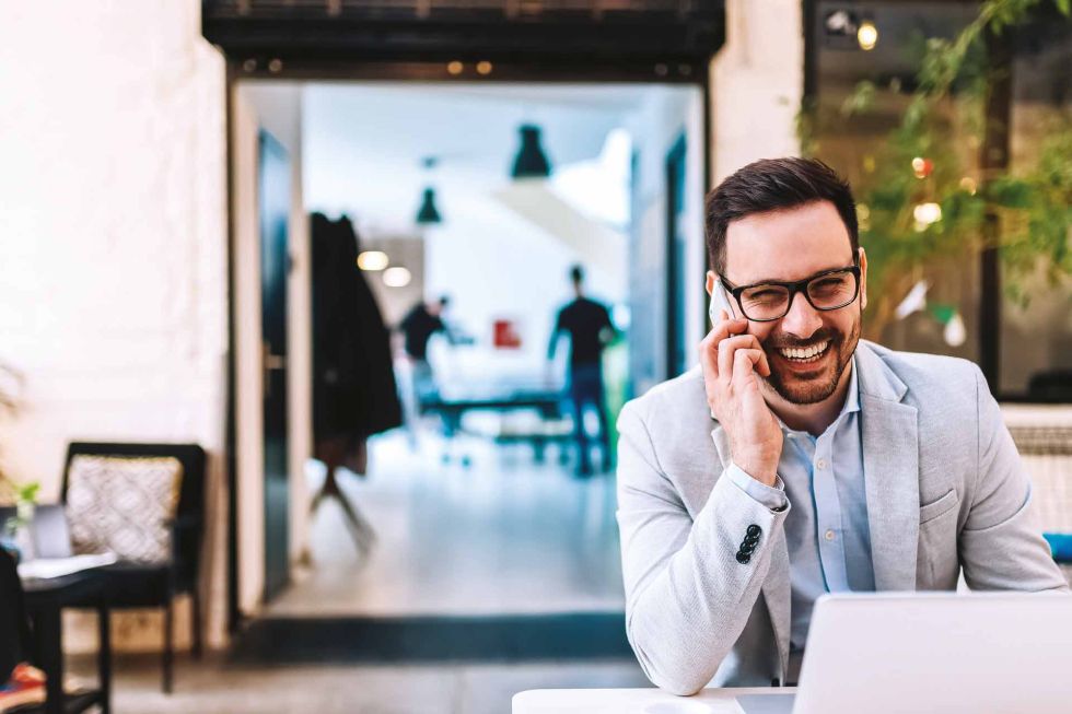 Man on a mobile phone and laptop
